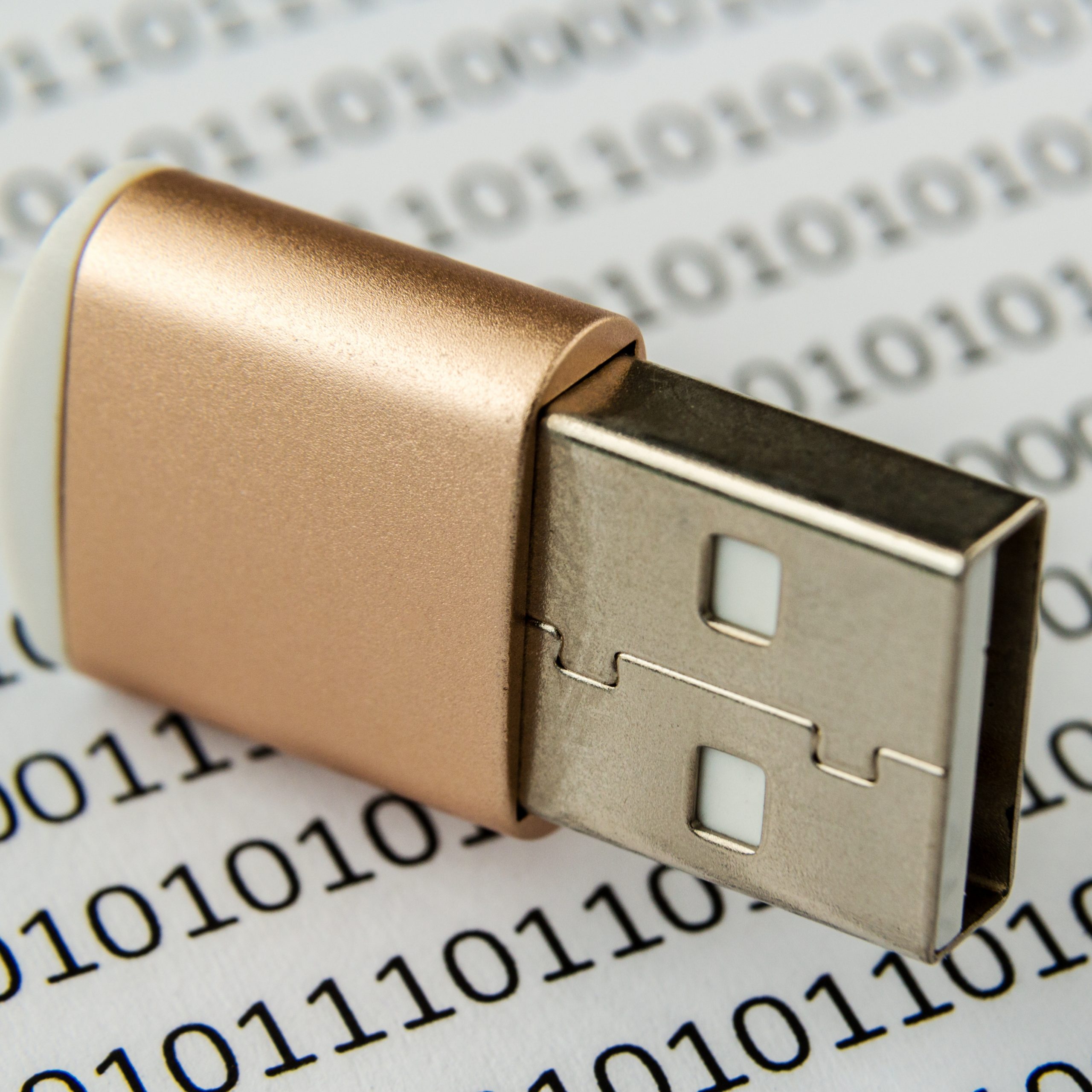 Closeup shot of a USB cable on a piece of paper with numbers and codes written on it